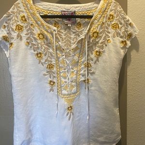 Johnny was white blouse with yellow flower embroidery